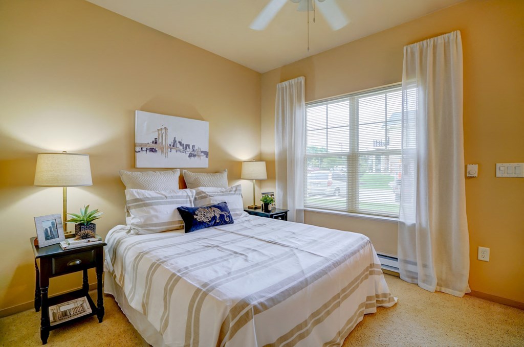 a bedroom with a bed and a large window