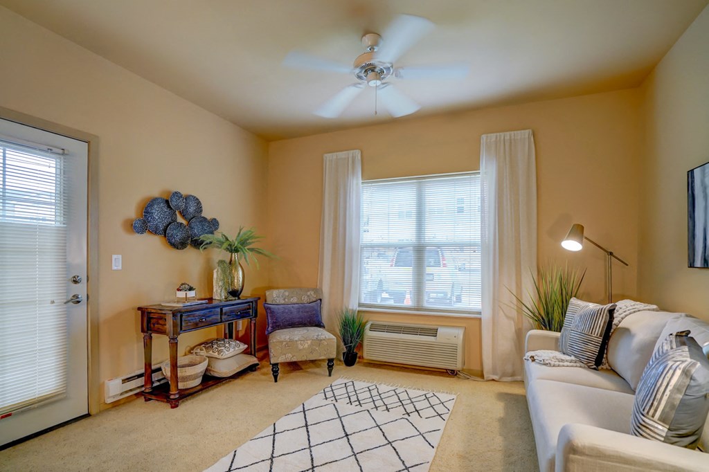 a living room with a white couch and a ceiling fan