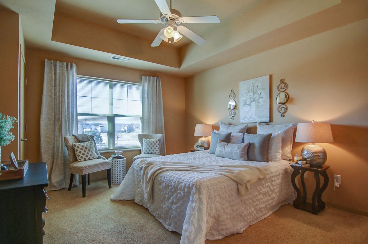 a bedroom with a large bed and a ceiling fan