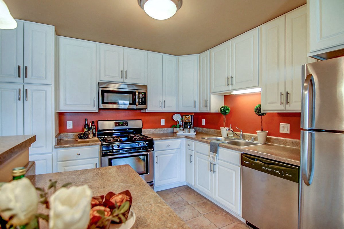 a kitchen with white cabinets and stainless steel appliances