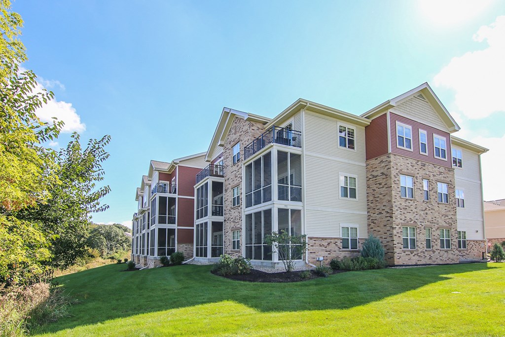an exterior view of an apartment building with a green lawn