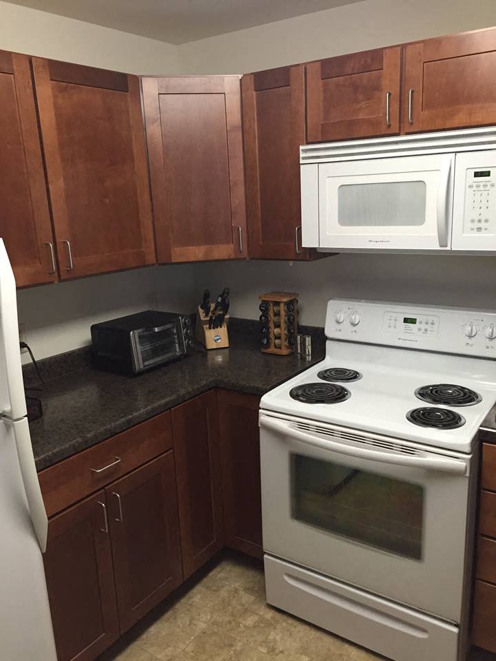 a kitchen with white appliances and wooden cabinets