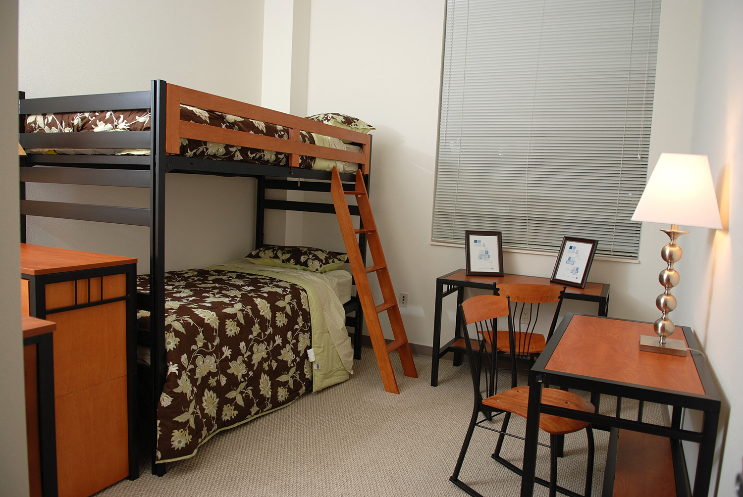 a bedroom with bunk beds and a desk and a window