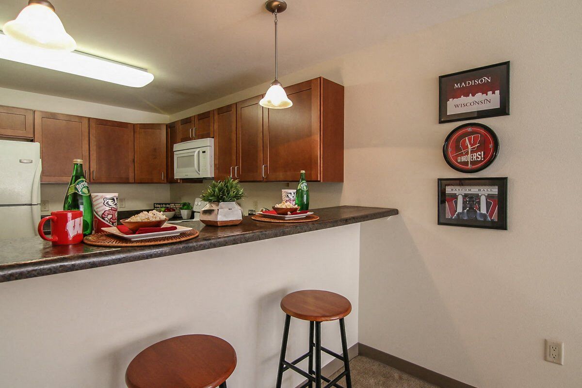a kitchen with a counter and a bar with two stools