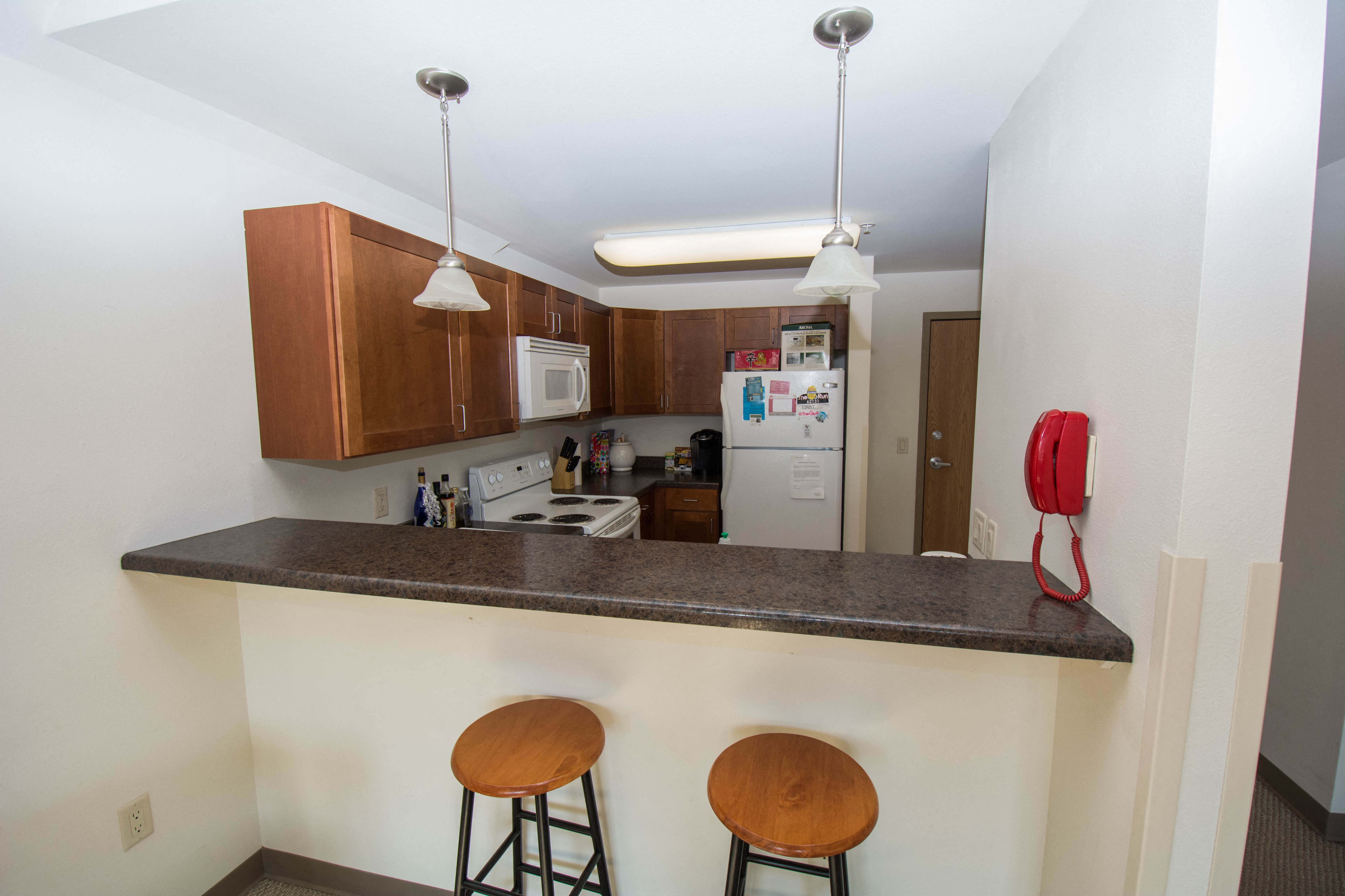 a kitchen with a counter and three stools