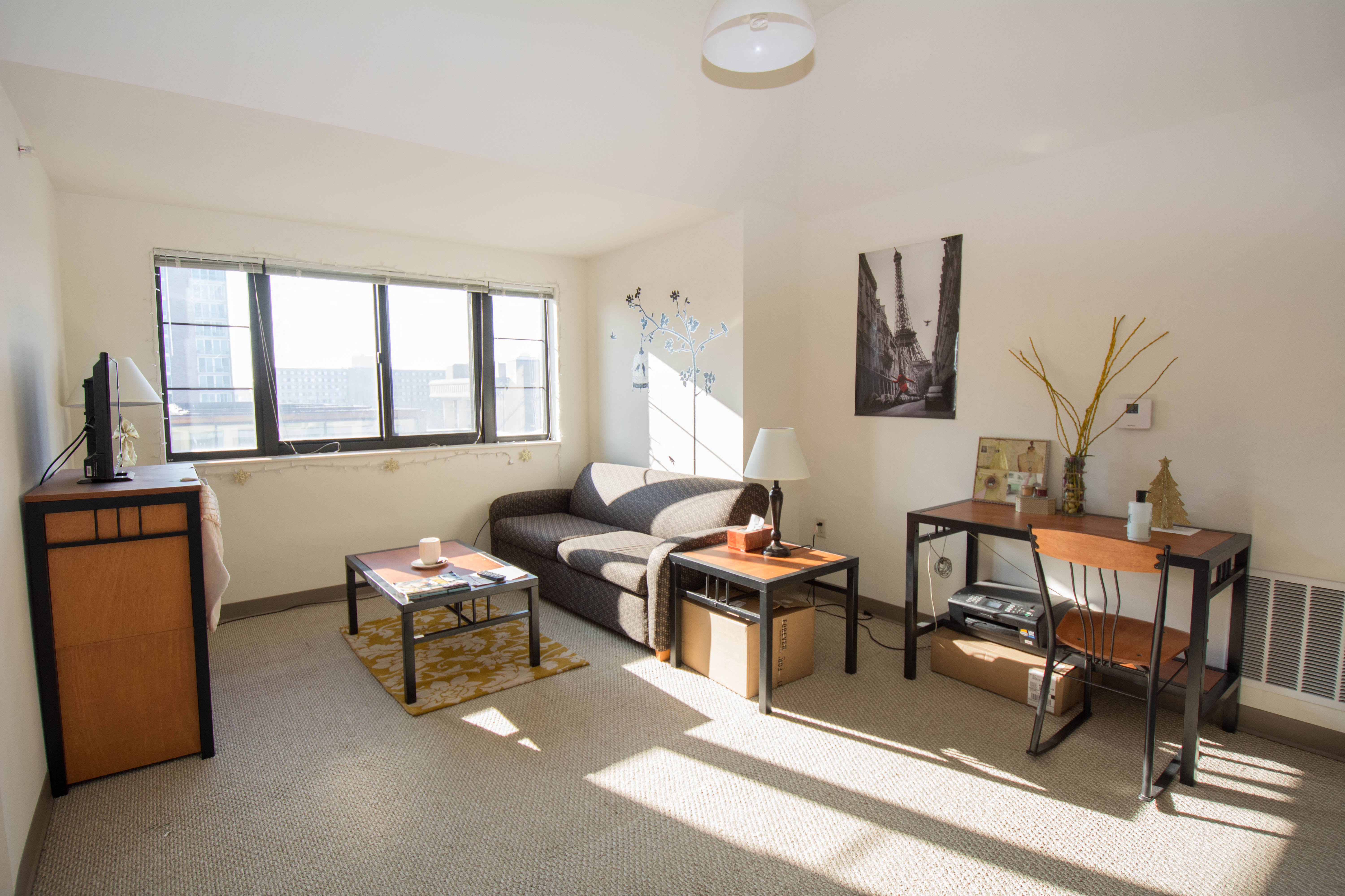 a living room with a couch and two tables and a window