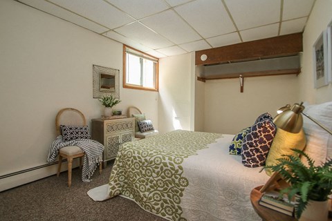 a bedroom with a bed and a chair and a window