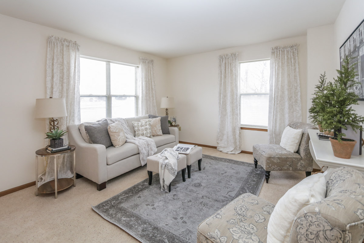a living room with couches and chairs and a rug