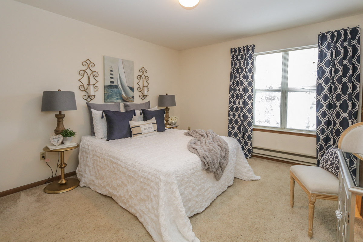 a bedroom with a bed and a window with curtains
