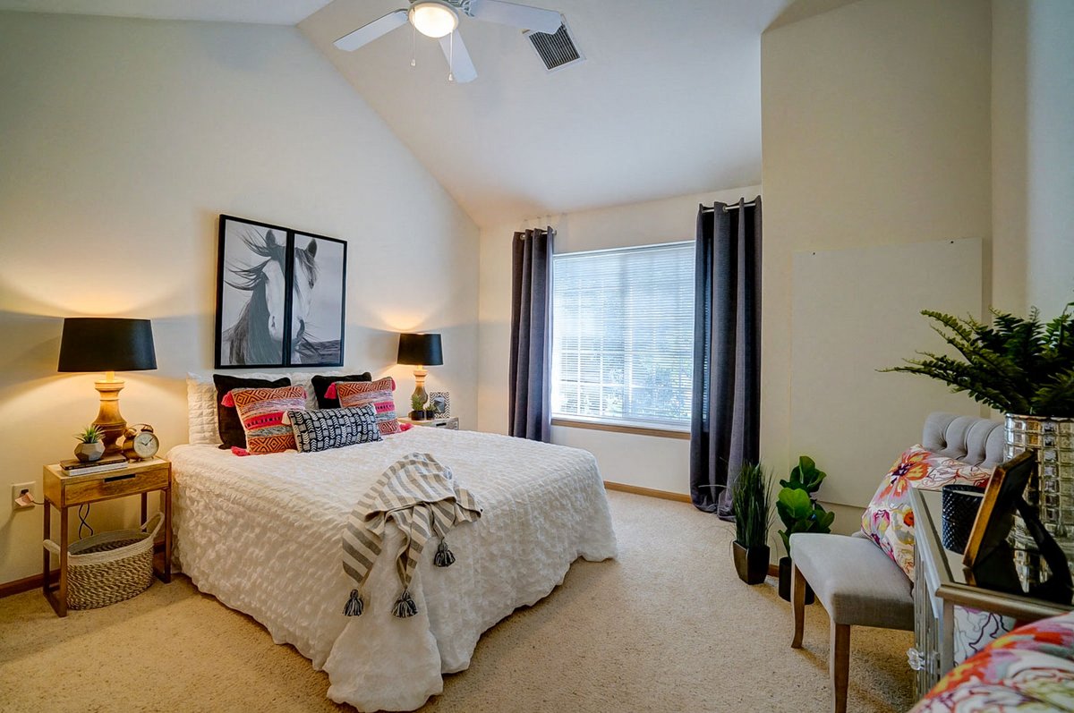 a bedroom with a bed and a ceiling fan