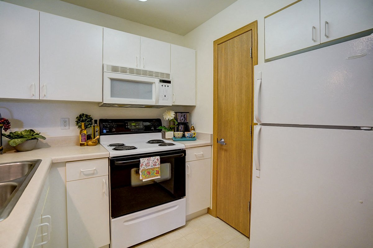 a kitchen with white appliances and white cabinets