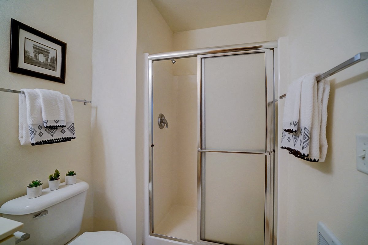 a bathroom with a shower and a toilet and some towels