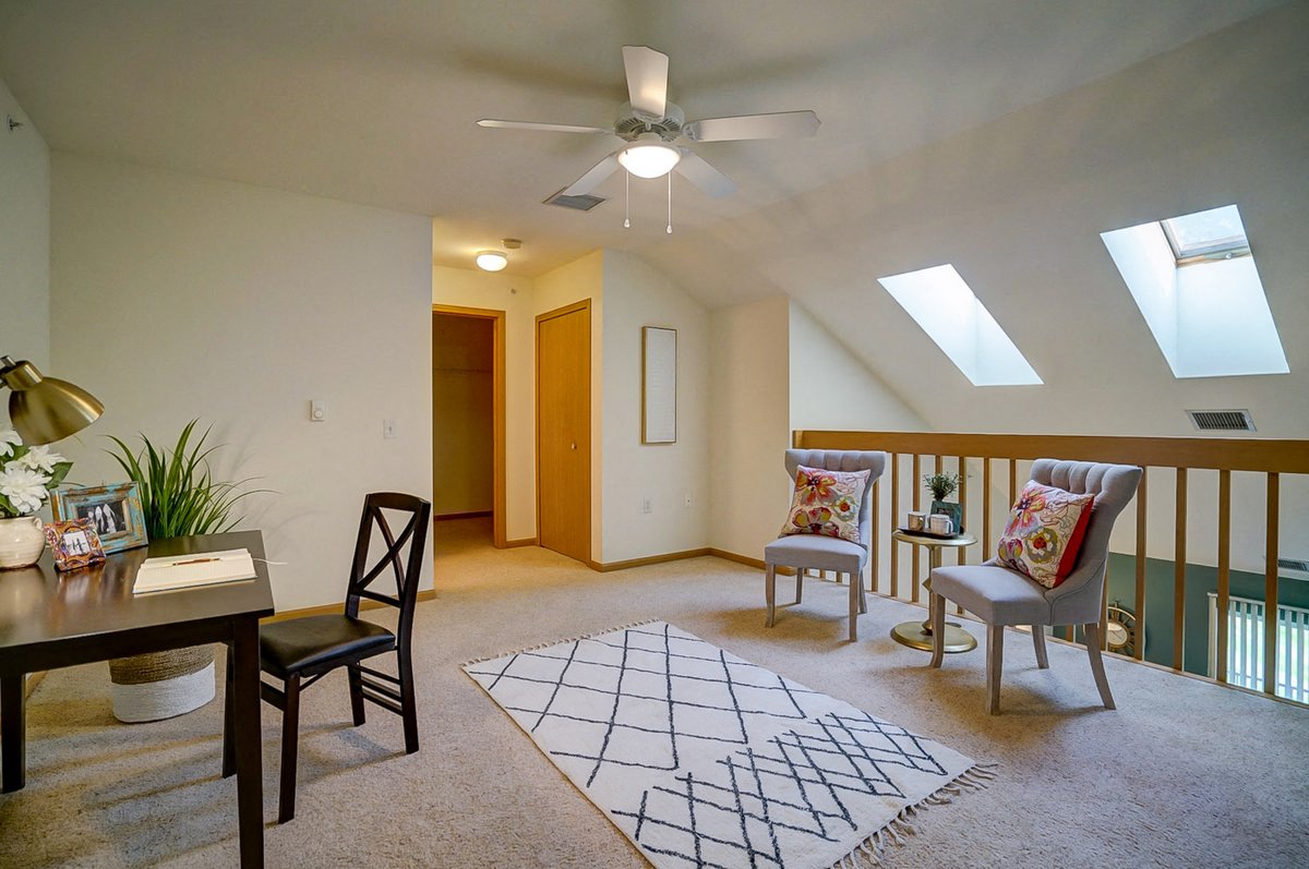 a living room with furniture and a ceiling fan