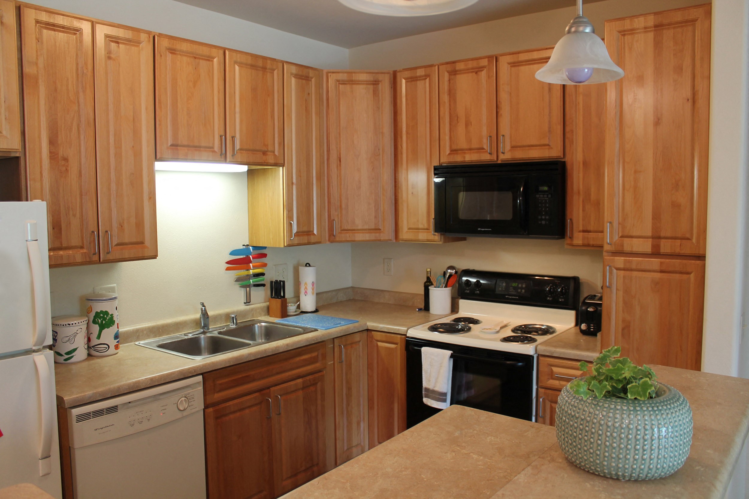 a kitchen with wooden cabinets and a stove and a sink