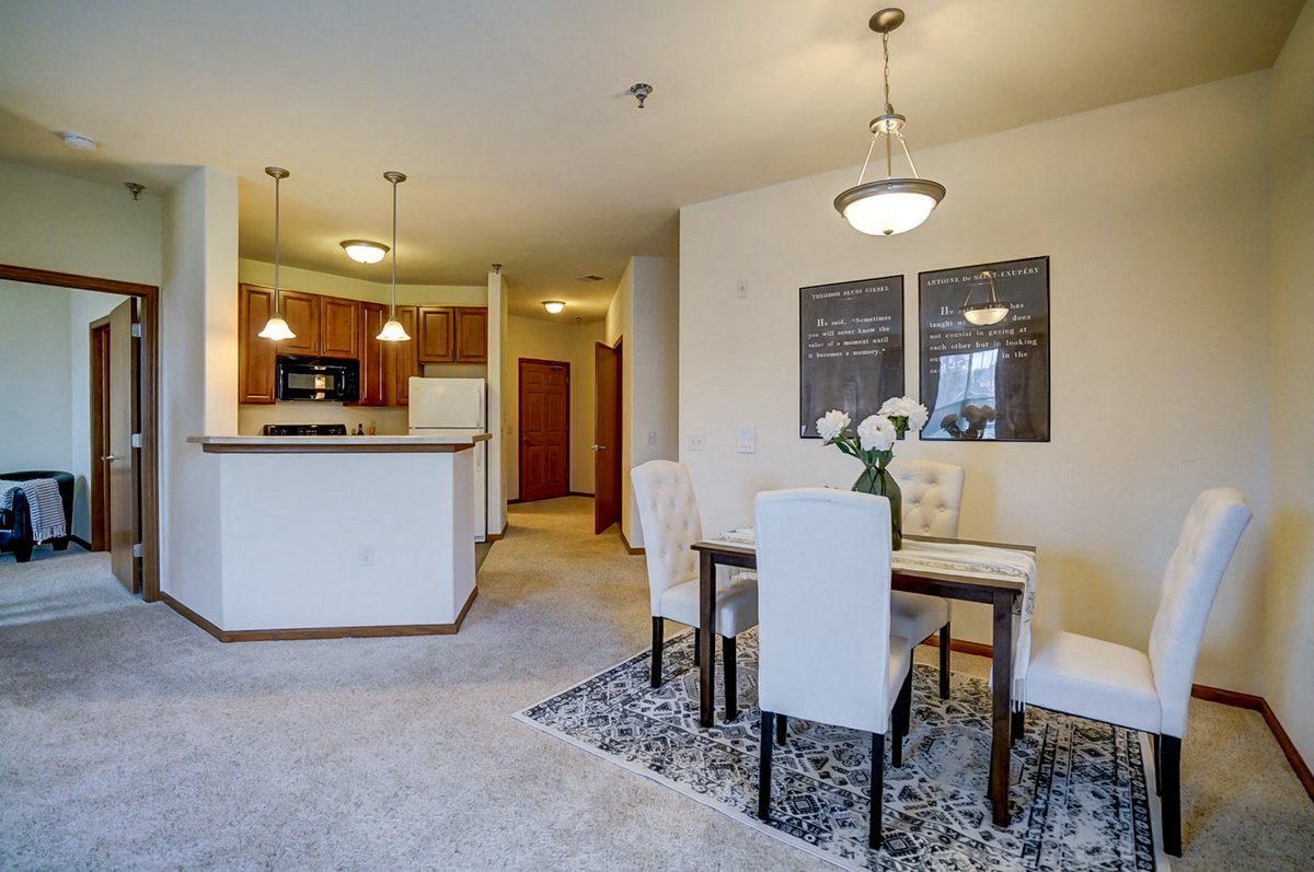 a dining room and kitchen with a table and chairs