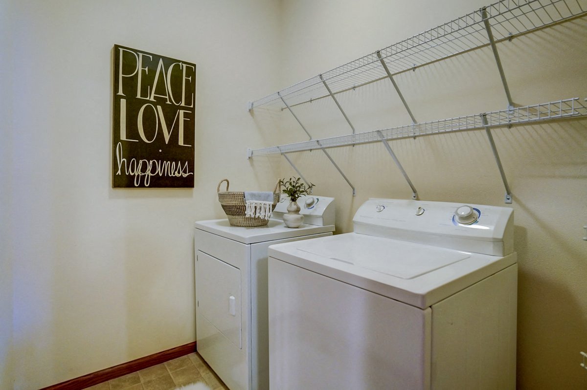 a washer and dryer in a laundry room with a sign