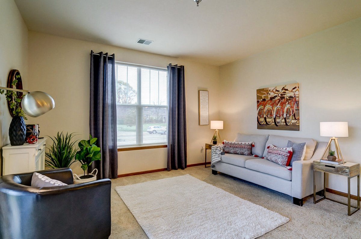 a living room with a couch and a chair and a window