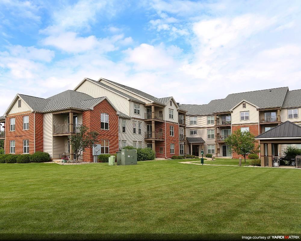 an image of an apartment complex with a green lawn