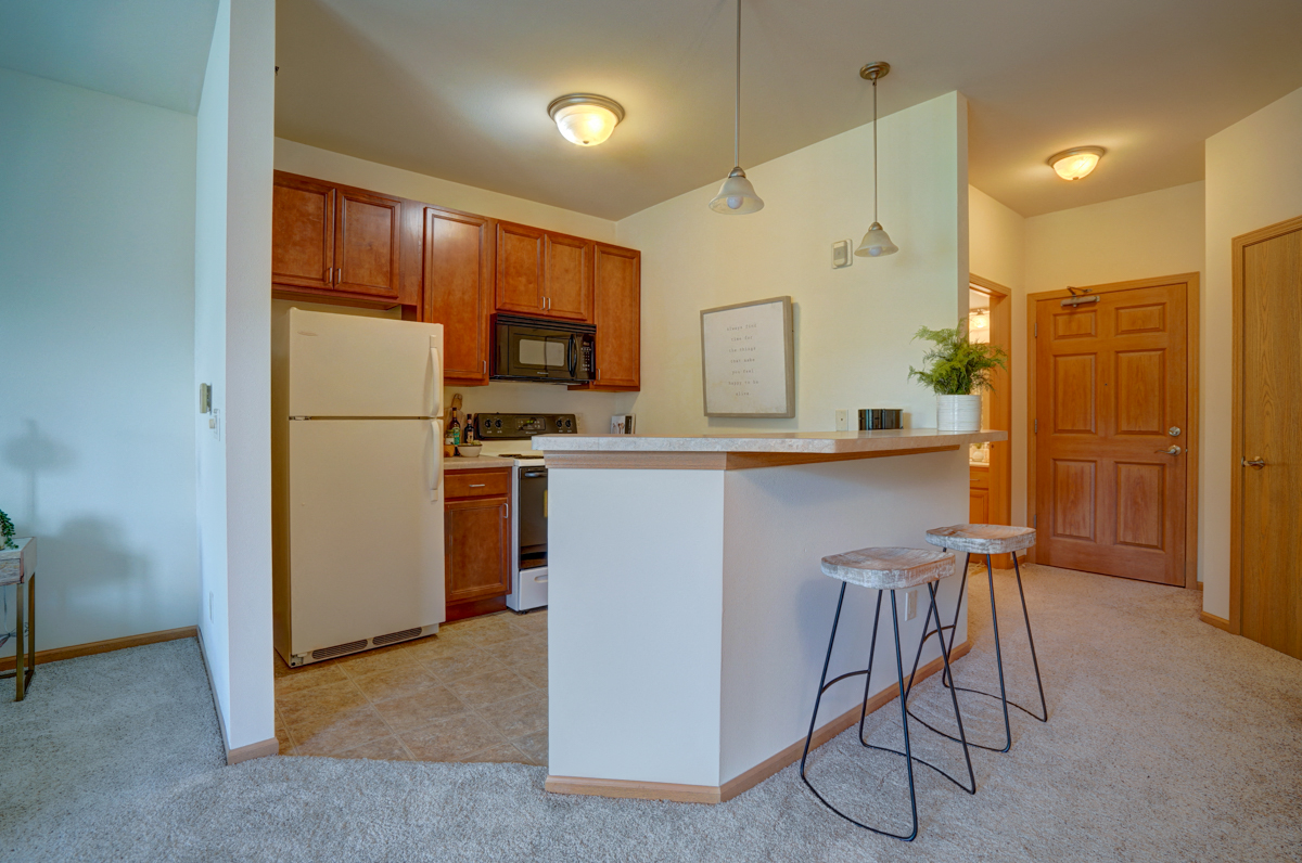an open kitchen with a bar and stools