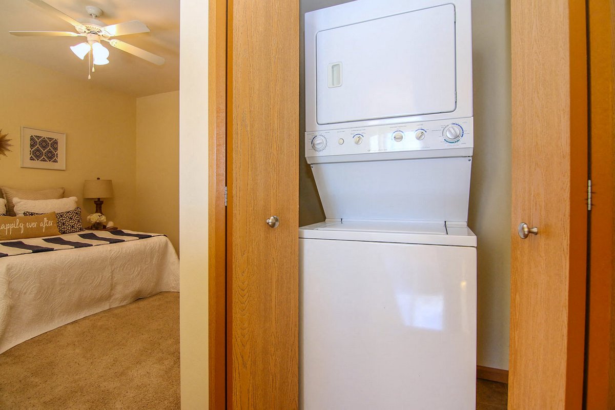 a bedroom with a white washer and dryer in it