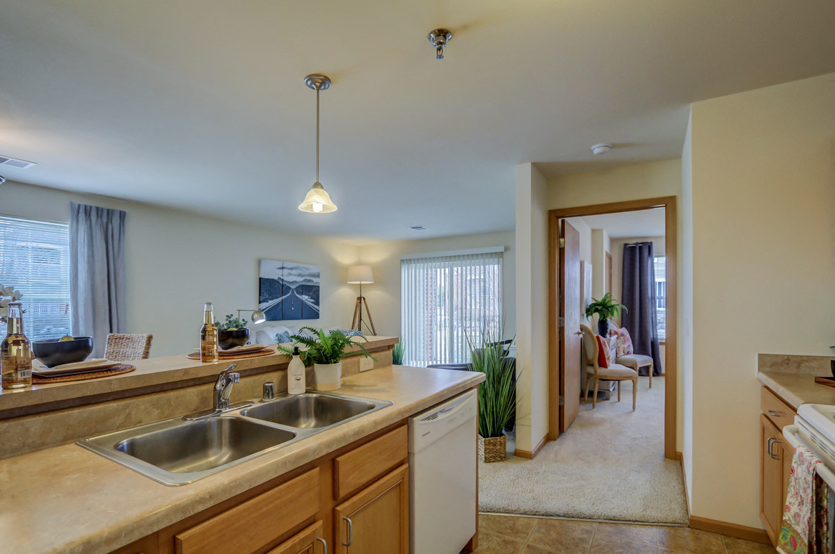 a kitchen with a sink and a living room with a dining room and a hall