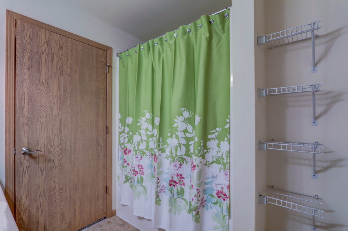 a closet with a shower curtain and a wooden door