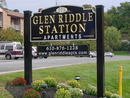 a sign for glen riddle station apartments in front of a street