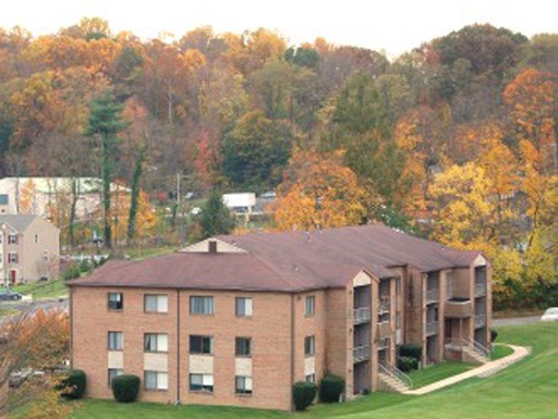 a large brick building with trees in the background