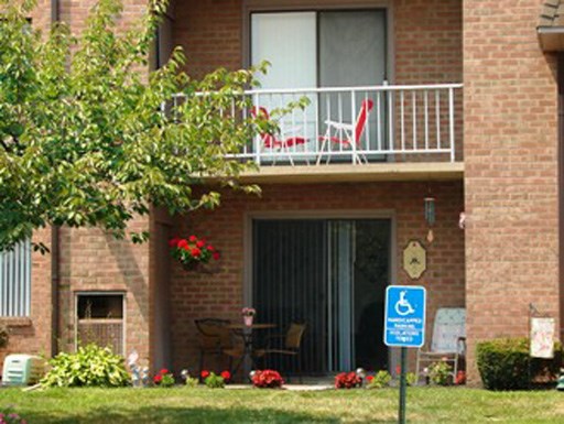 a building with a balcony and a handicapped sign in front of it