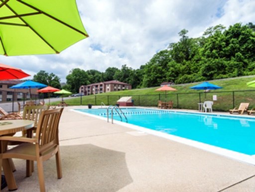a swimming pool with tables and chairs and umbrellas