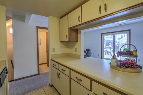 a kitchen with a counter top and a door to a living room