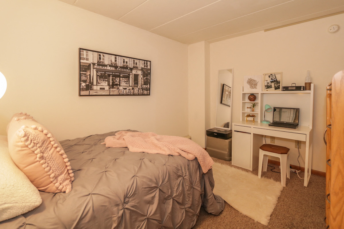 a bedroom with a bed and a desk and a television