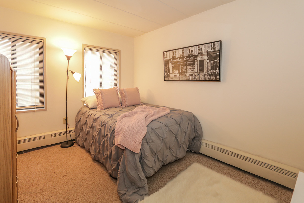 a bedroom with a bed and two windows