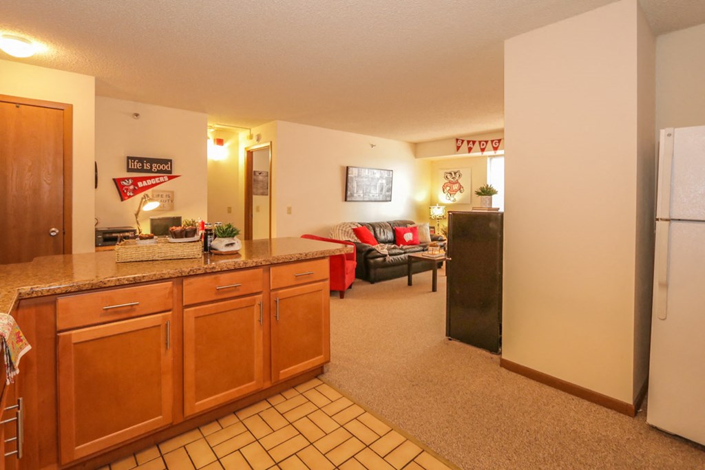 the kitchen is open to the living room with a refrigerator