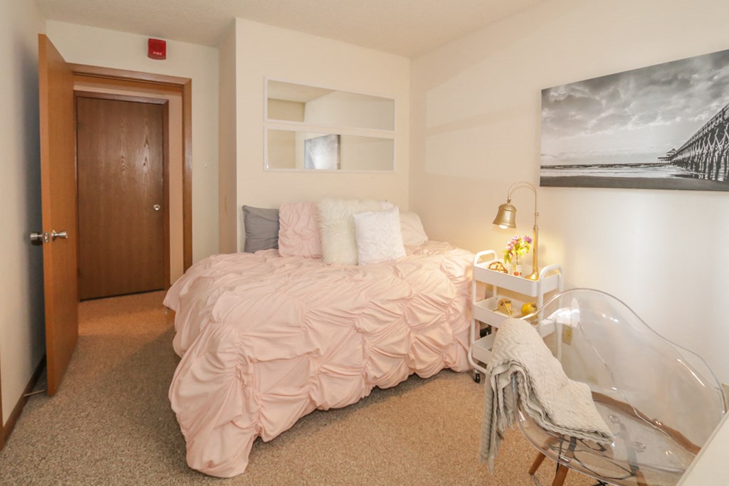 a bedroom with a bed and a desk and a door