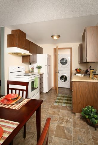 a kitchen with a table and a refrigerator and a washing machine