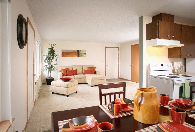 a kitchen and living room with a table and chairs