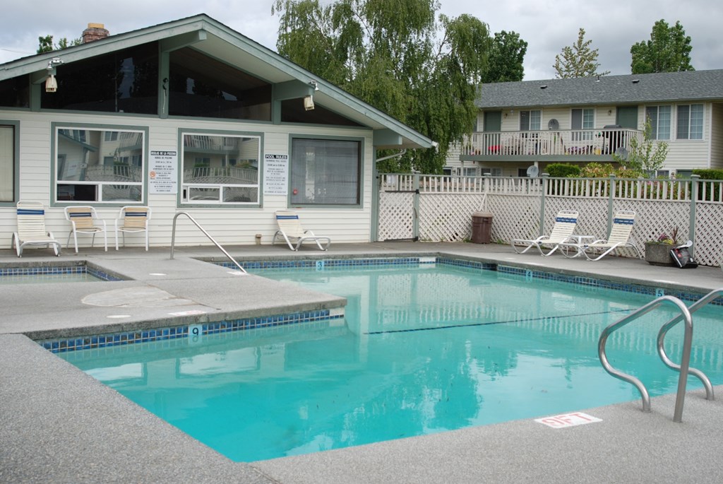 a swimming pool with a house in the background