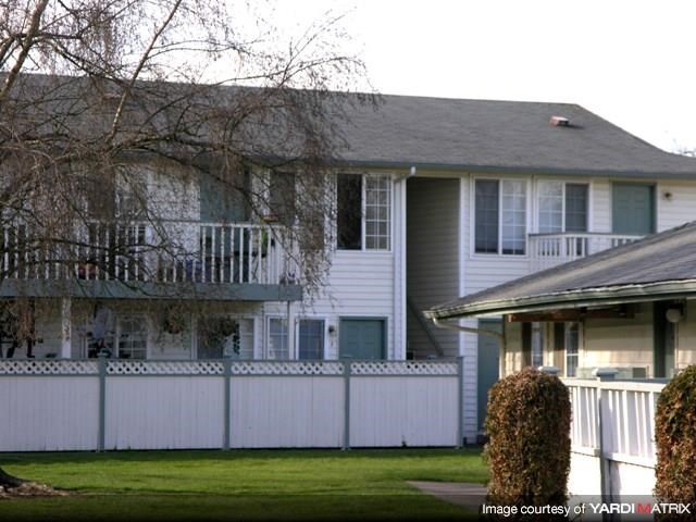 a white house with a porch and a white fence