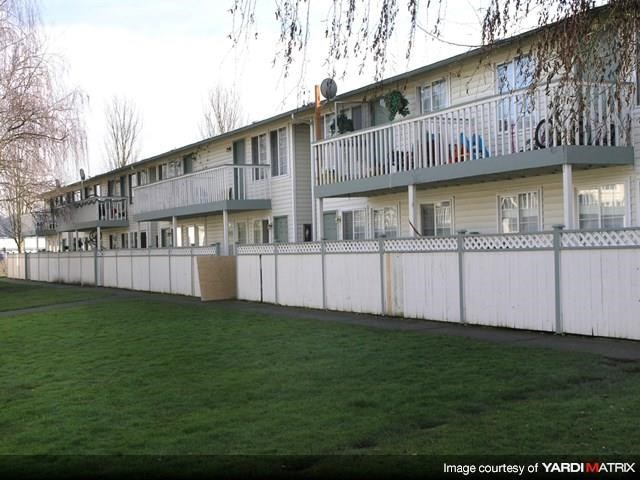 a white fence in front of an apartment building
