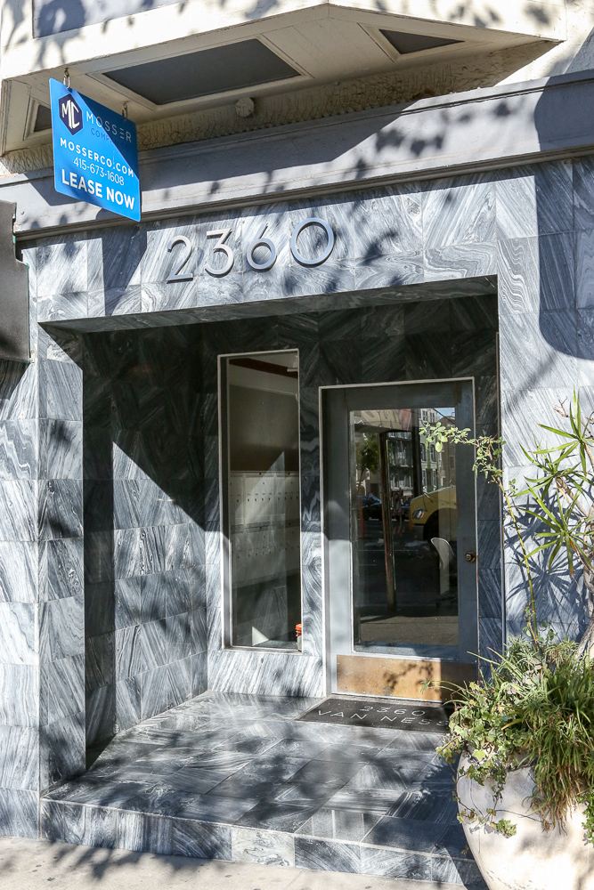 a blue and white building with a door and a street sign