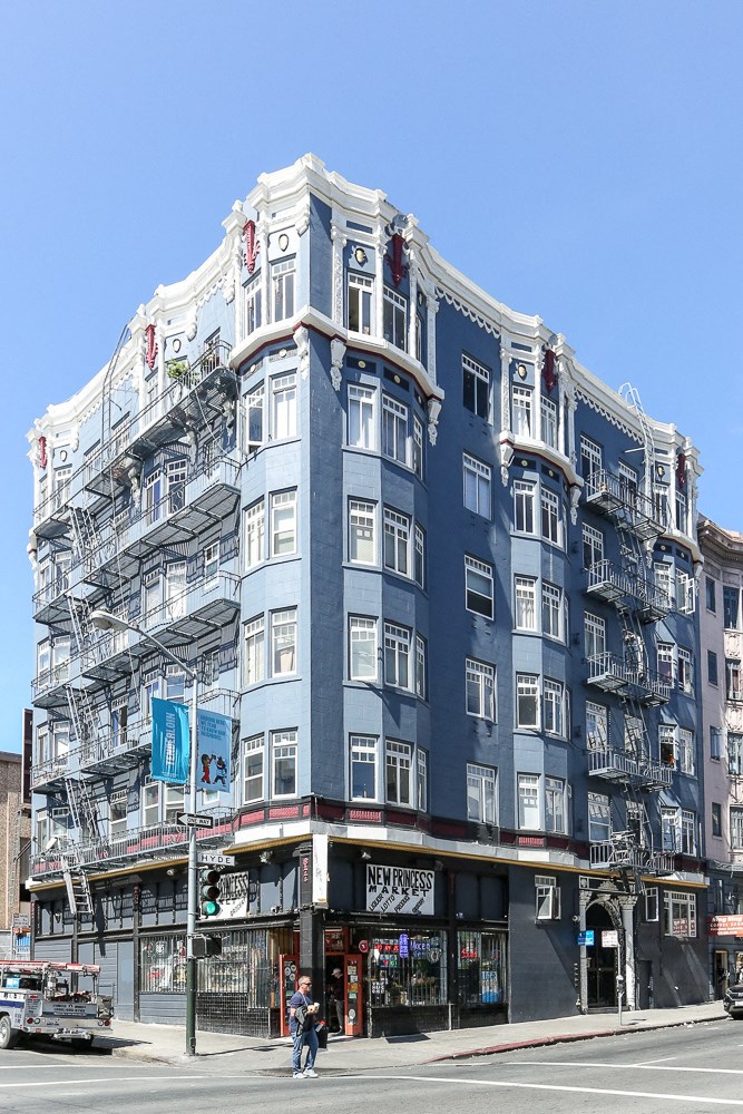 a blue building with a fire escape on a city street