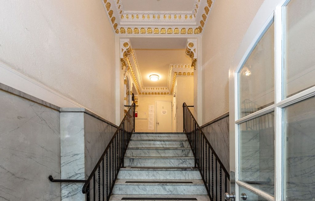 the stairs of a building with marble steps and a gold ceiling
