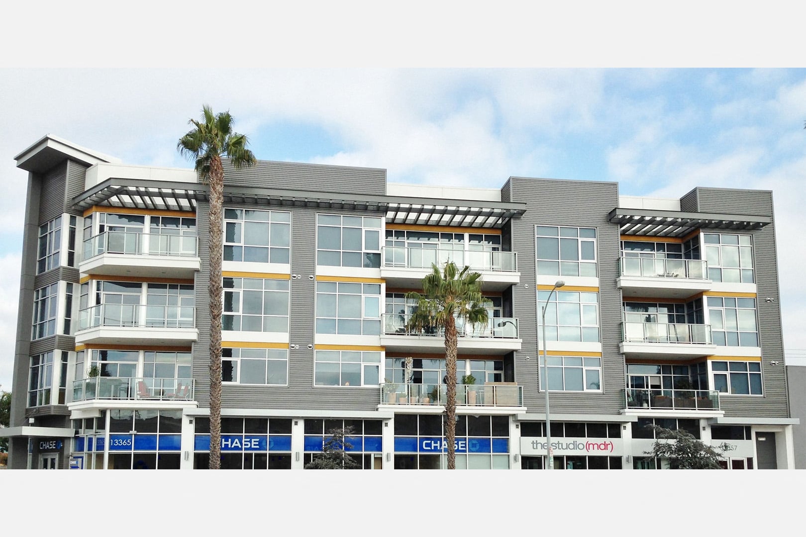 A modern building with a palm tree in front.
