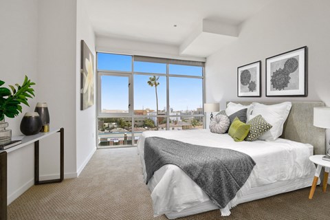 A bedroom with a large bed and a view of the city.