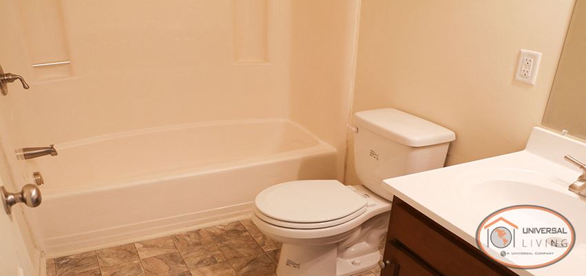 a bathroom with a toilet and a tub and a sink