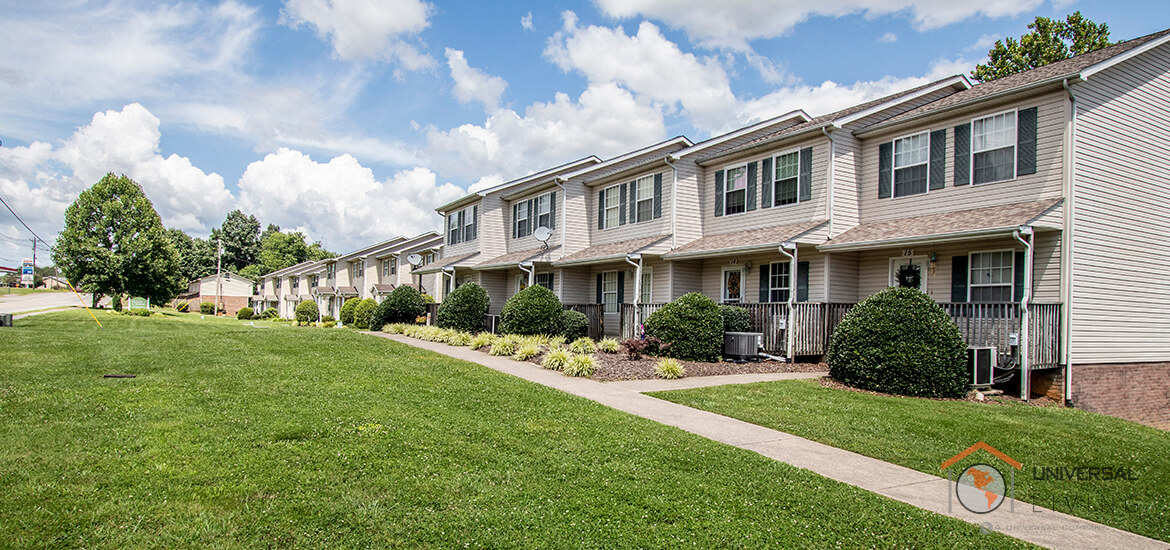 a row of houses on a sidewalk with grass