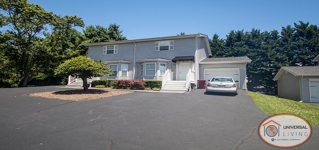 a blue house with a car parked in front of it