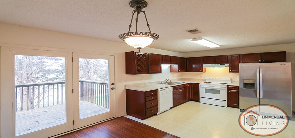 a kitchen with a sliding glass door to a balcony