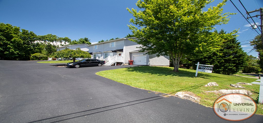 a white house with a black car parked in front of it